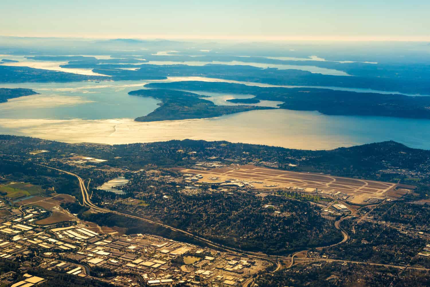 Seattle-Tacoma International Airport from the air with the southern end of Puget Sound in late afternoon light