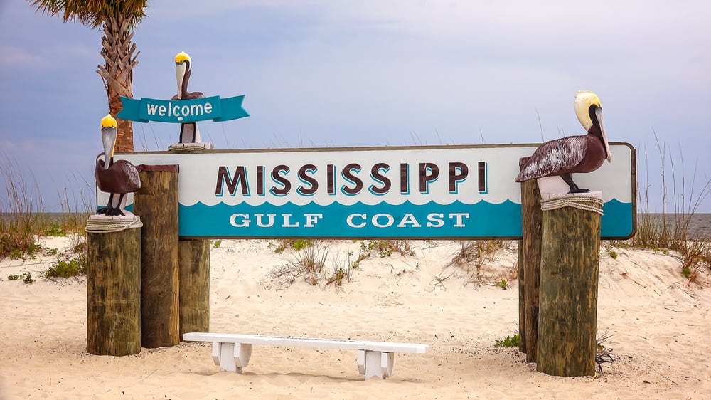 Welcome to Mississippi Gulf Coast sign on sandy beach in Gulfport