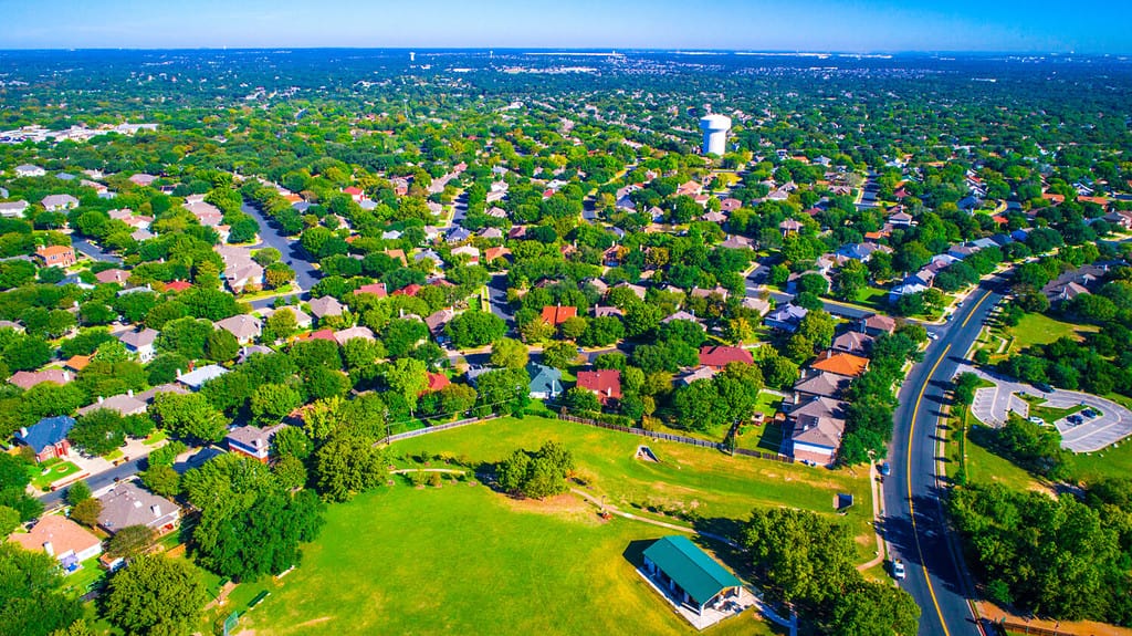 Green scape never ending houses and homes Round Rock , Texas , USA Suburb growing outside of Austin high aerial drone view green summer colorful morning Millions of Homes vast Neighborhood Suburbia