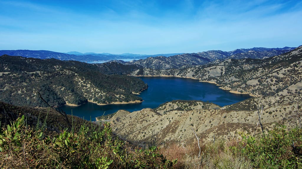 Aerial view of Lake Berryessa from the Blue Ridge Trail, Stebbins Cold Canyon, on a sunny day, featuring the surrounding blue oak woodland and ta small stretch of highway 128 in the fall of 2017