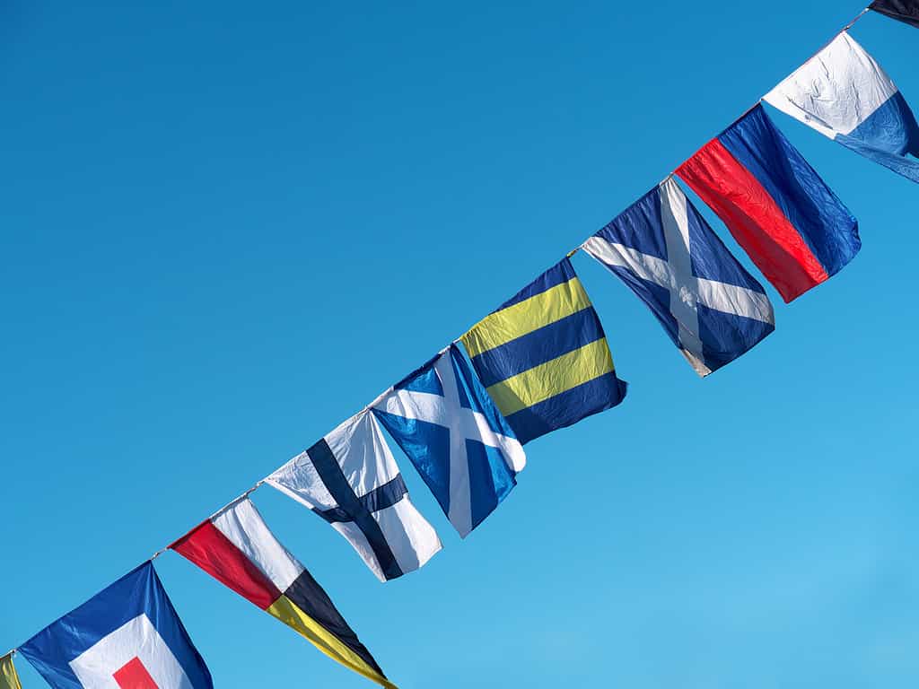 Nautical flags against blue sky.