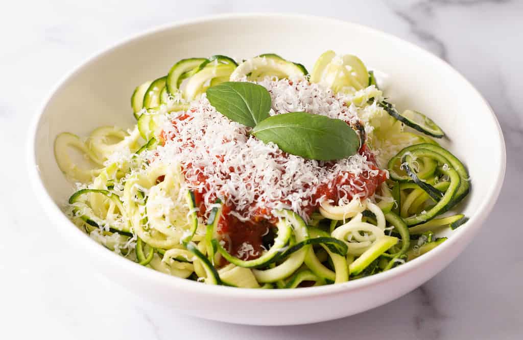 Zucchini Pasta Topped with Parmesean Cheese and Tomato Sauce