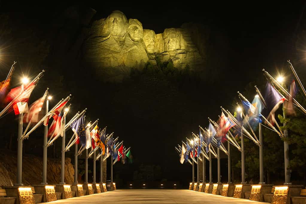 Lit up Rushmore above flags