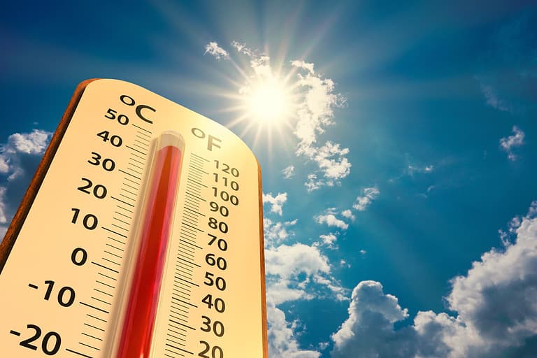 low angle view Thermometer on blue sky with sun shining