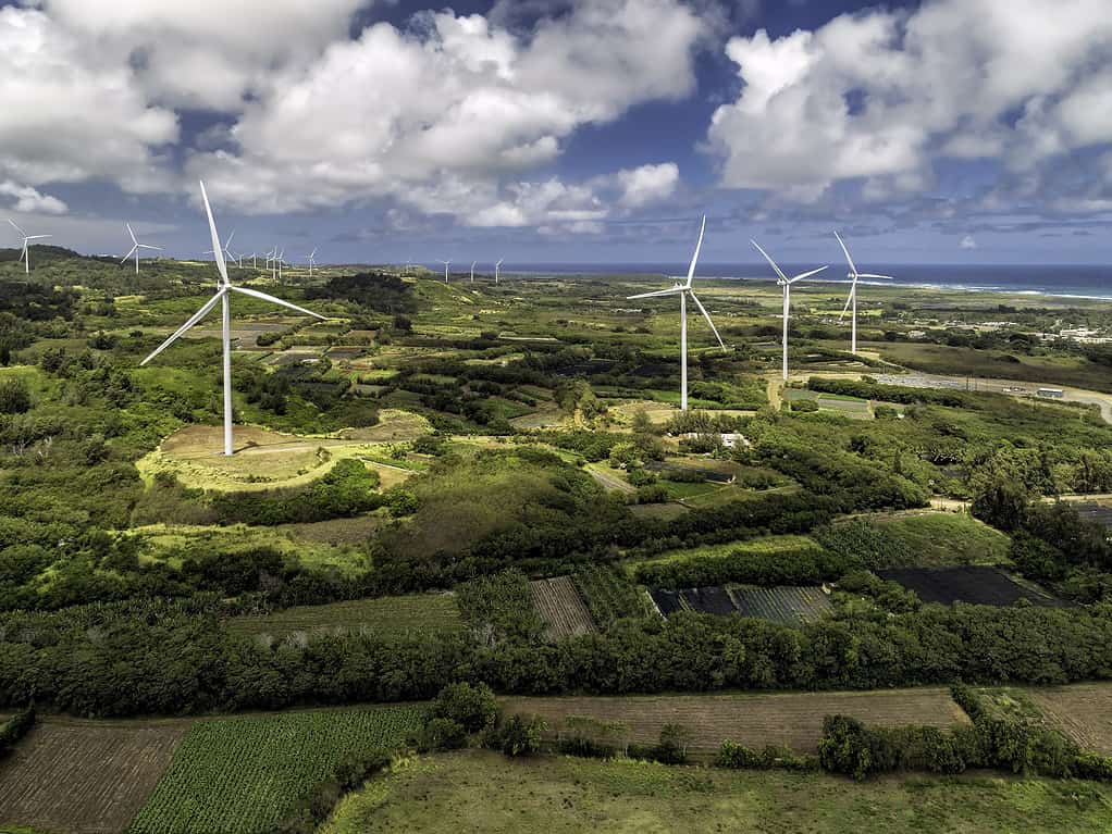 Wind power turbines on Kahuku Wind farm in Oahu, Hawaii. Blue sunny sky with white clouds