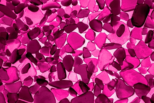 Sea glass background in Viva Magenta. Red leaf top view
