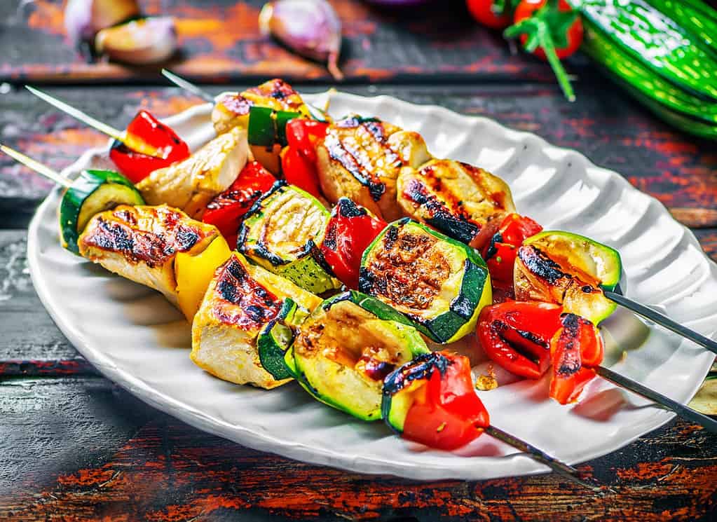 Grilled meat skewers chicken shish kebab with zucchini tomatoes and red onions