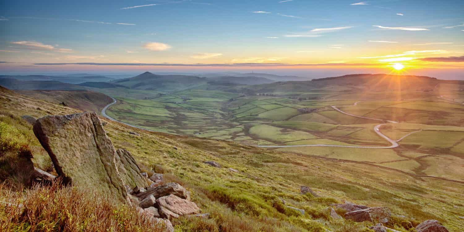 Awesome colours illuminate the Cheshire countryside with Shutlingsloe in the distance viewed from the rocks and boulders on Shining Tor. The Cat and Fiddle Road snakes through the image.