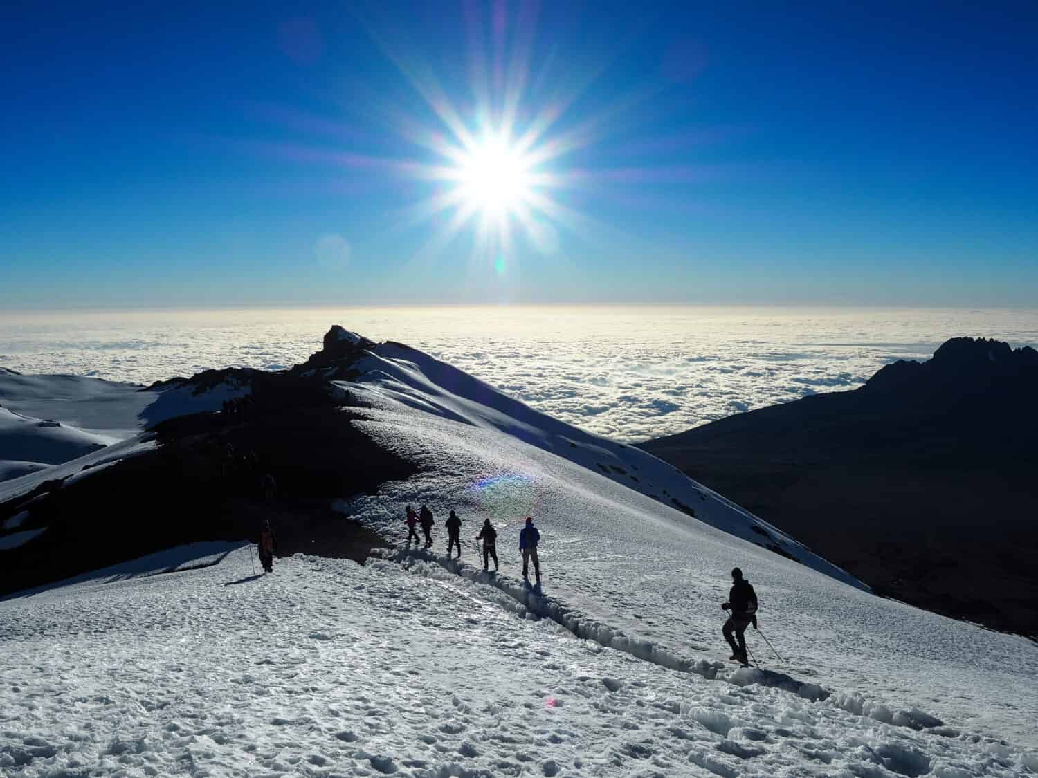 Hikers make their way to the summit of Mount Kilimanjaro on the snow
