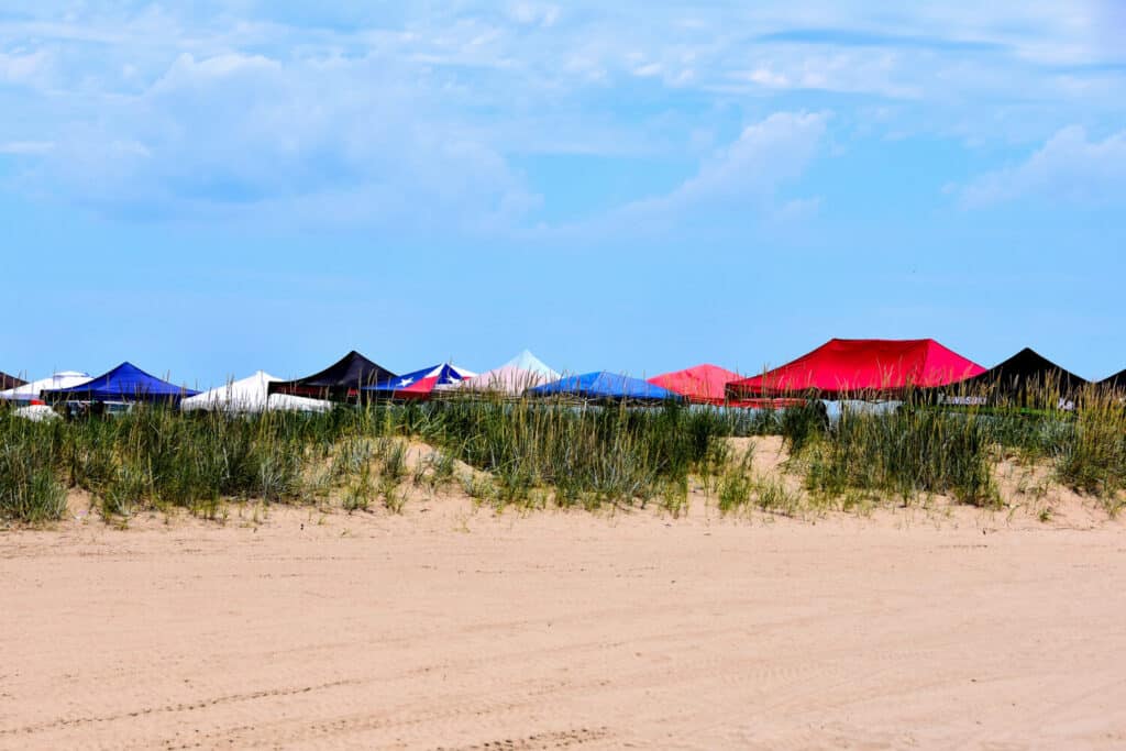 A row of tent covers at Racine Wisconsin's North Beach on a beautiful summer day just beyond the sand dunes.