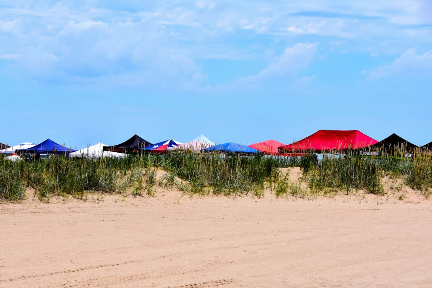 A row of tent covers at Racine Wisconsin's North Beach on a beautiful summer day just beyond the sand dunes. 