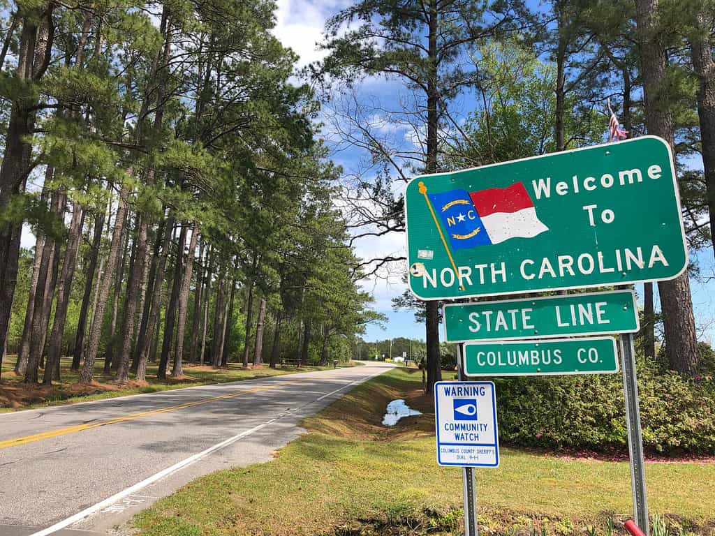 Welcome to North Carolina sign along a beautiful country road.