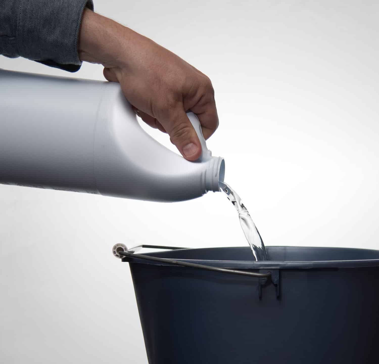 Bleach into a blue bucket against a white background.