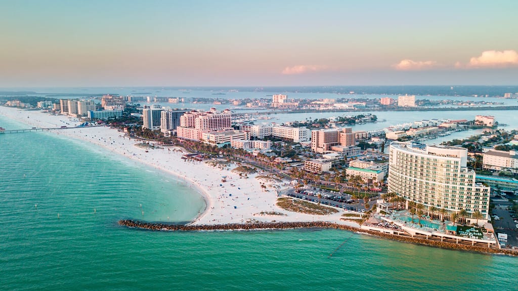 Panorama of city Clearwater Beach FL. Summer vacations in Florida. Beautiful View on Hotels and Resorts on Island. Blue color of Ocean water. American Coast or shore Gulf of Mexico. Sky after Sunset.