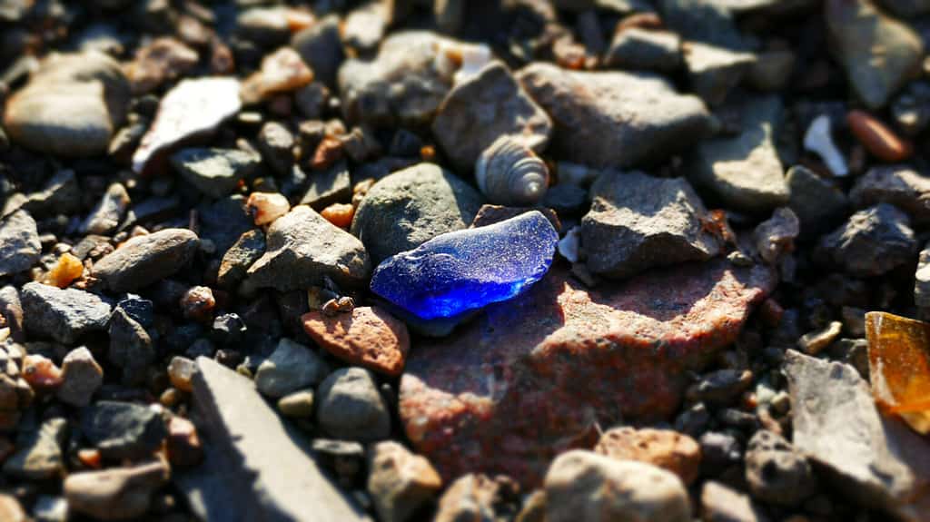 blue sea glass on a rocky beach