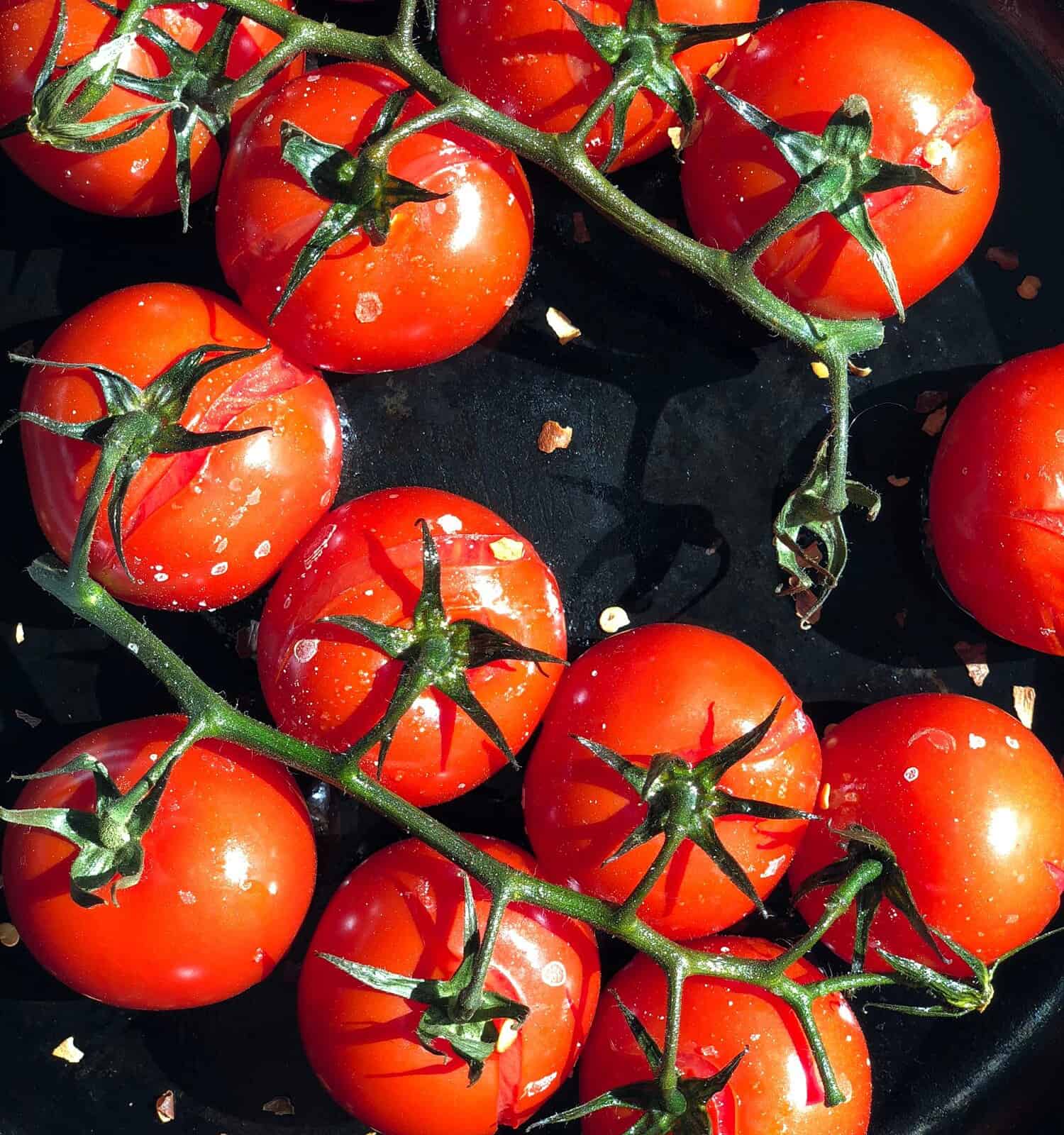 Roasted tomatoes on the vine in a cast iron pan