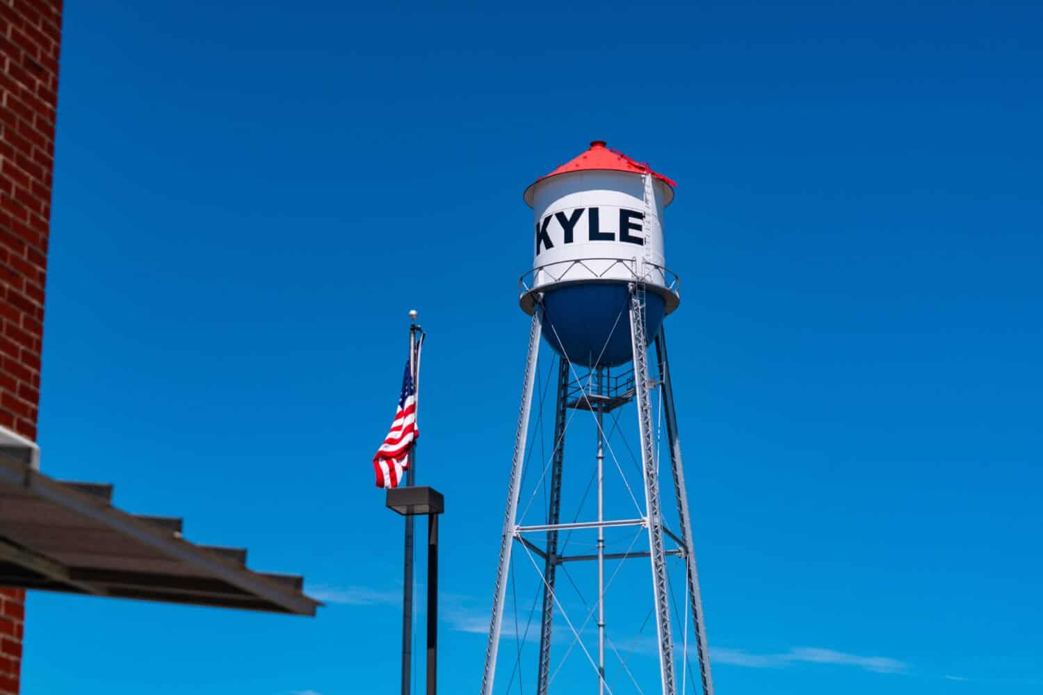 Red , white , and blue Water Tower in Small Town Texas with blue sky in Central Texas town Kyle , Texas , USA with American Flag on flagpole