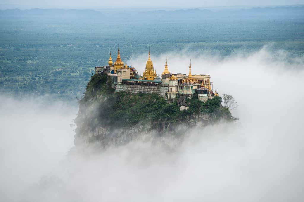 Spectacular view of Mount Popa over the clouds. Mt.Popa is the home of "Nat" the Burmese mythology ghost. This place is the old volcano in Myanmar.