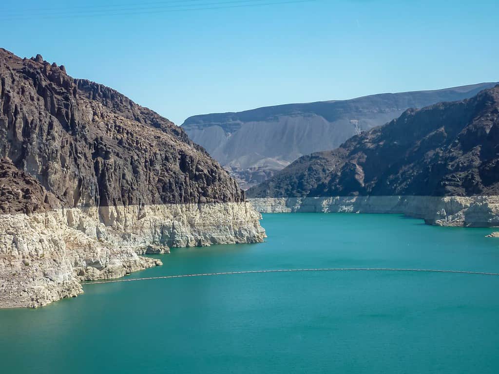 The Hoover Dam looking towards Lake Mead from the Mike O'Callaghan–Pat Tillman Memorial Bridge, Nevada Arizona state line, USA. Blue turquoise water surrounded by lush dry mountain ranges