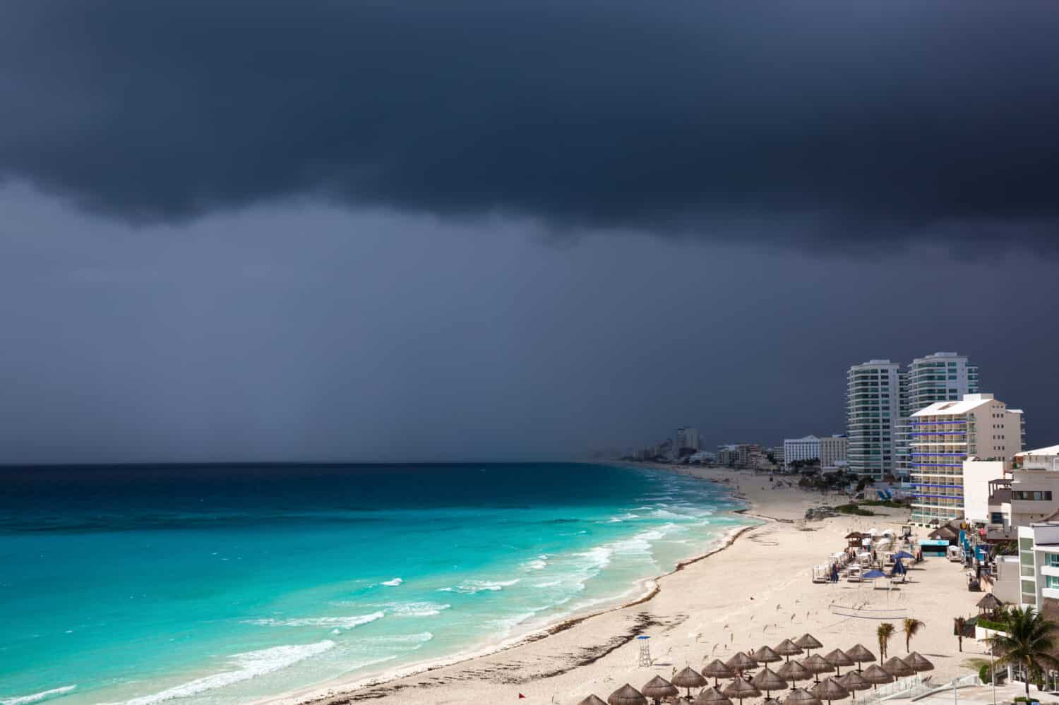 Stormy weather in Cancun, beautiful turquoise sea under dark blue clouds, view from above