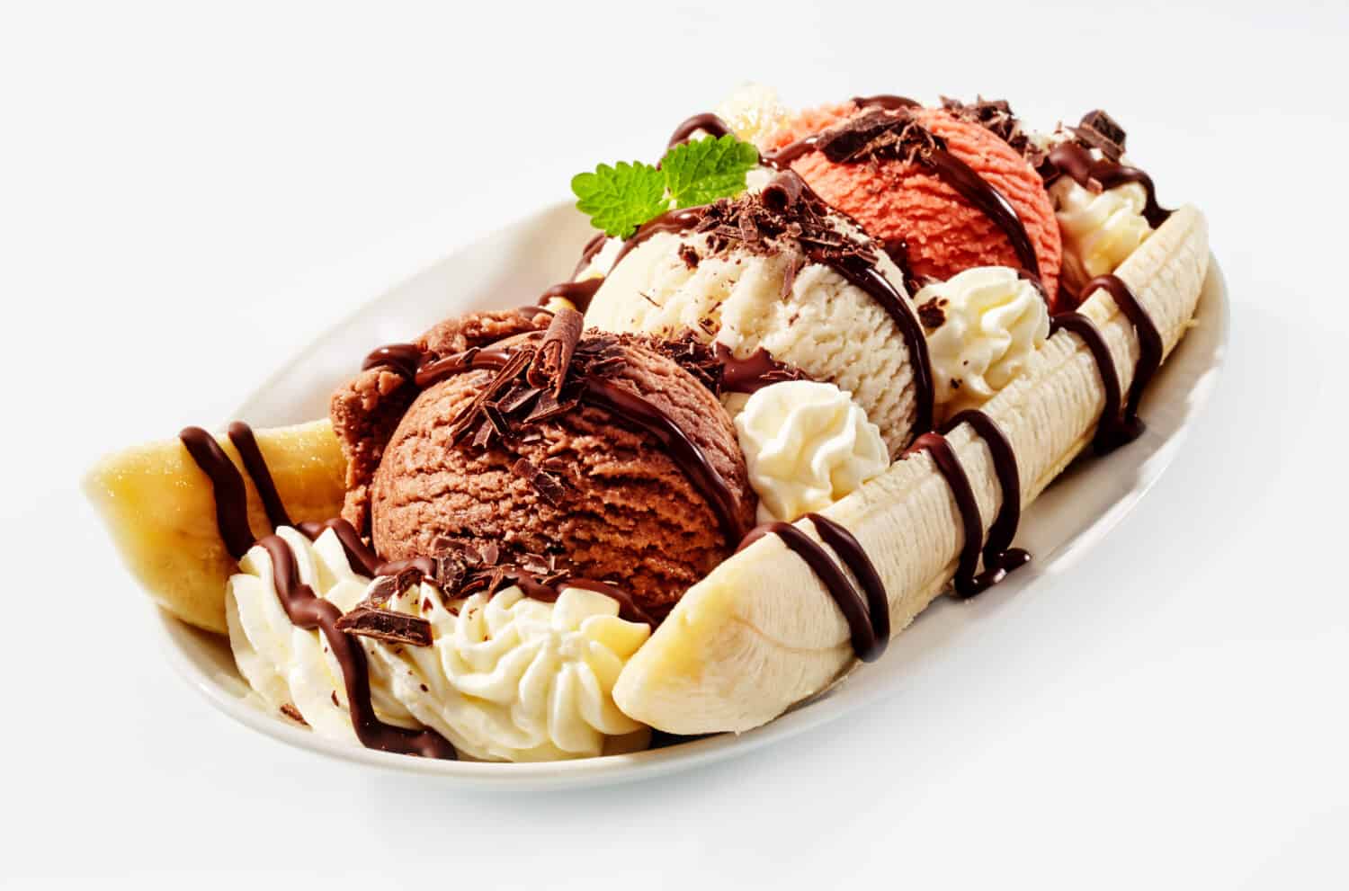 Banana split sundae ice cream in a bowl with strawberry and raspberry vanilla icecream scoops