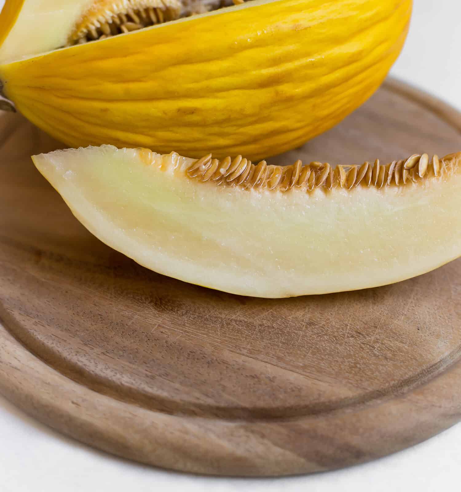 canary melon on a wooden board and a white background