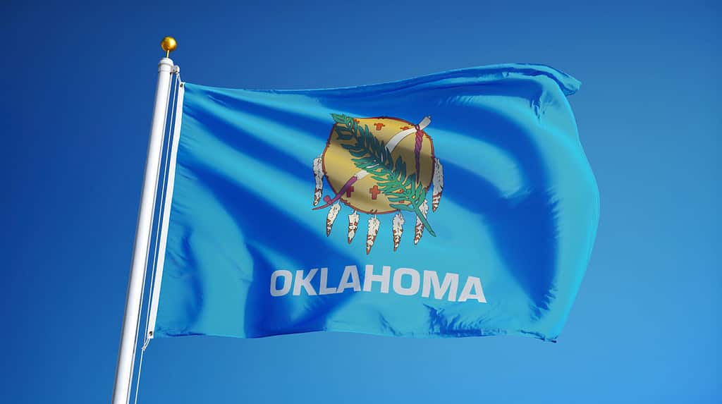 Oklahoma (U.S. state) flag waving against clear blue sky, close up, isolated with clipping path mask alpha channel transparency, perfect for film, news, composition