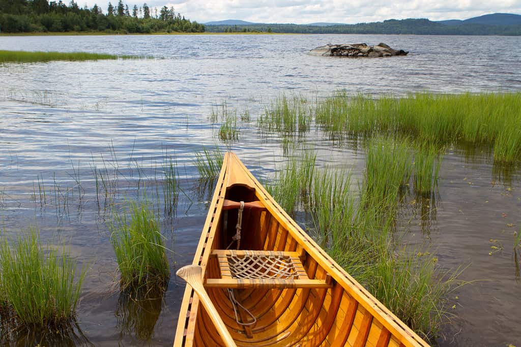 Hand crafted wooden canoe waiting to go out for a paddle to explore one of the beautiful lakes in the north Maine woods