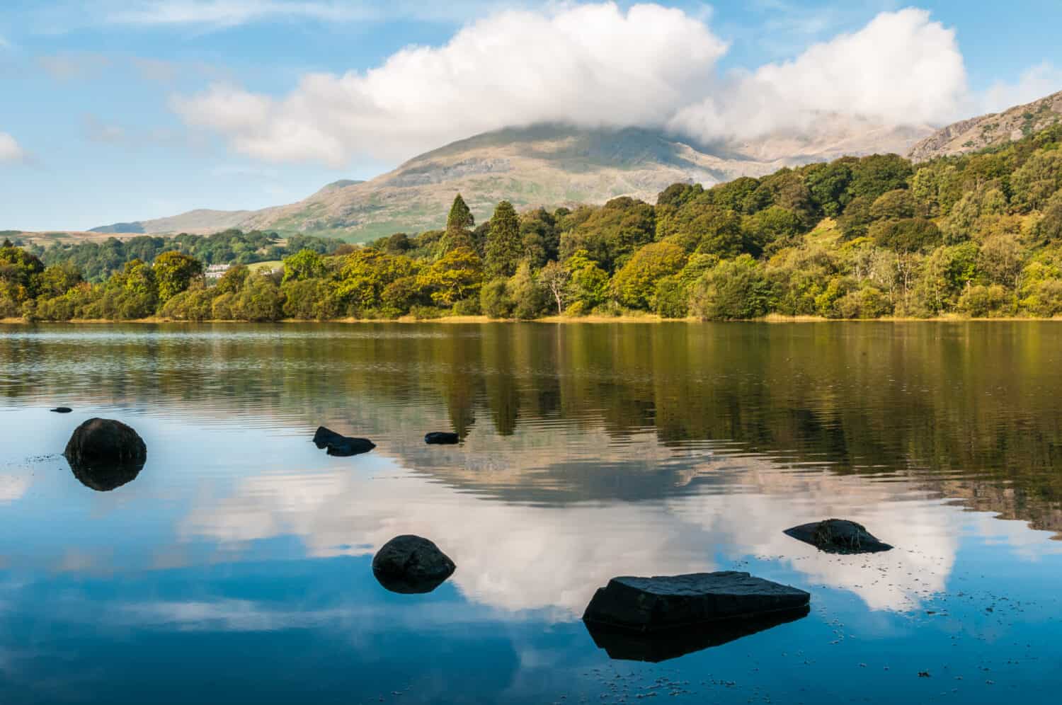 An early morning view of Coniston Water in the English Lake District. The summit of Coniston Old Man in the background is hiding in the clouds.