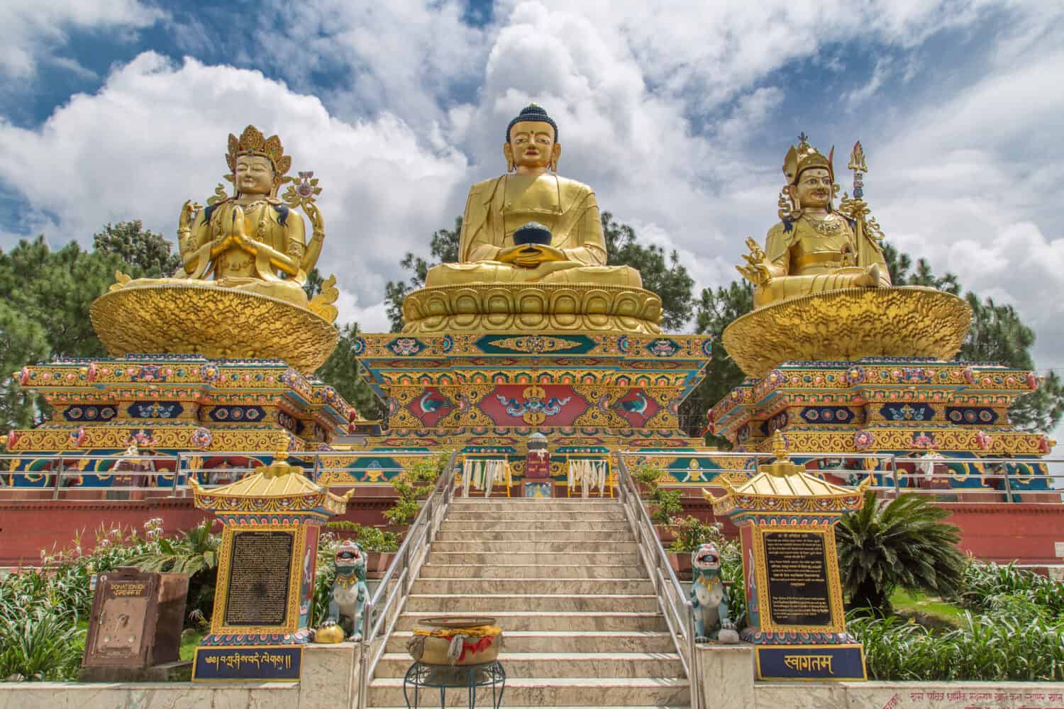 Big golden statues of Avalokiteshvara, Buddha Shakyamuni and Padmasambhava on lotus thrones in Buddha park, Swayambhunath area, Kathmandu, Nepal