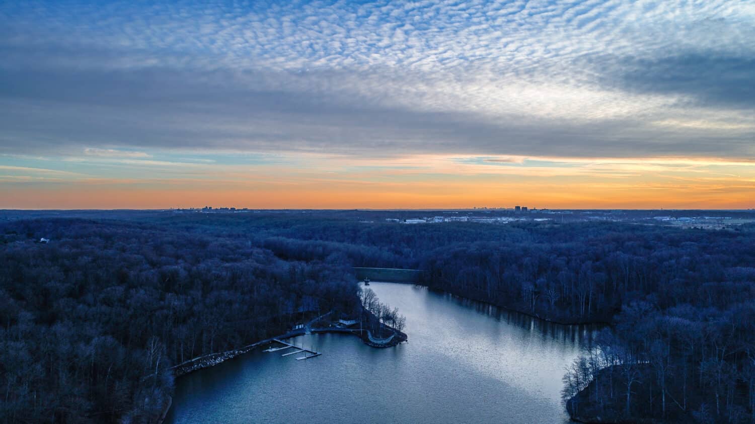 An aerial late afternoon drone view of Needwood Lake, which is part of Rock Creek Regional Park in Derwood, Maryland.