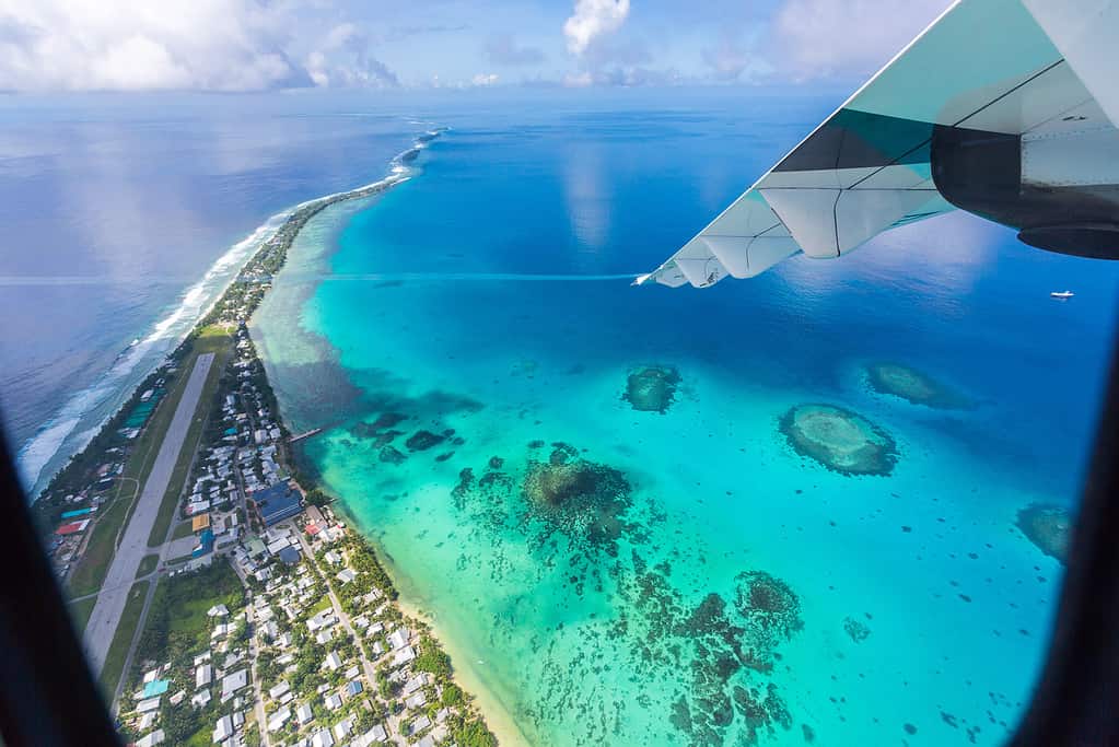 Tuvalu under the wing of an airplane, aerial view of airport. Vaiaku, Fongafale motu, Funafuti atoll, Tuvalu, Polynesia, South Pacific Ocean, Oceania