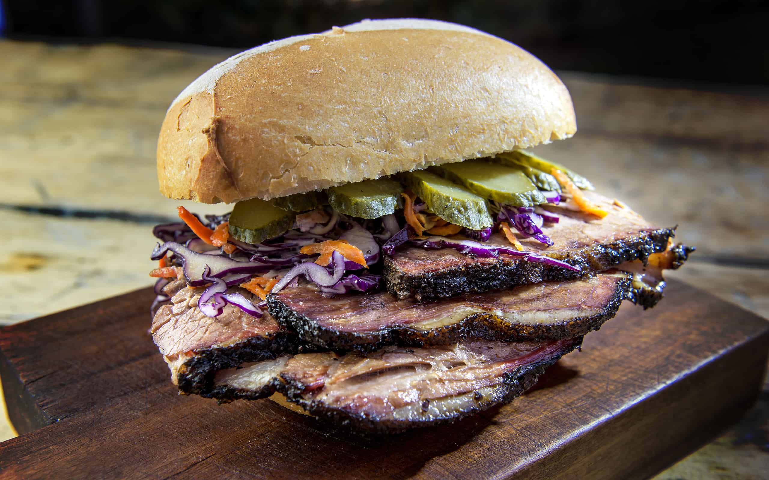 Brisket Sandwich with cucumber and coleslaw on cutting board