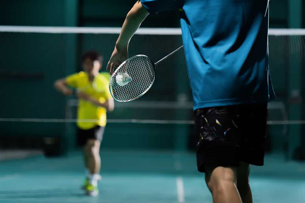 Badminton players engaging in a match. 