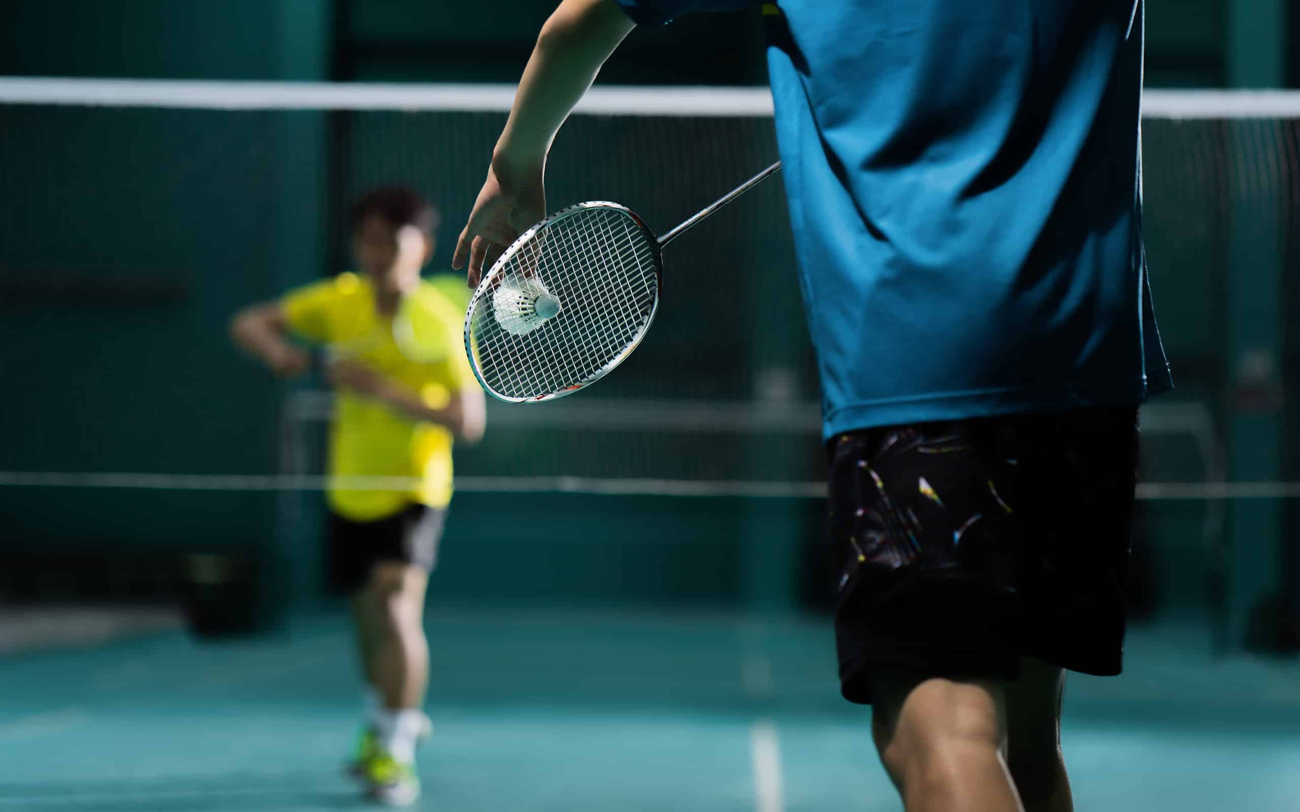 Badminton players engaging in a match.