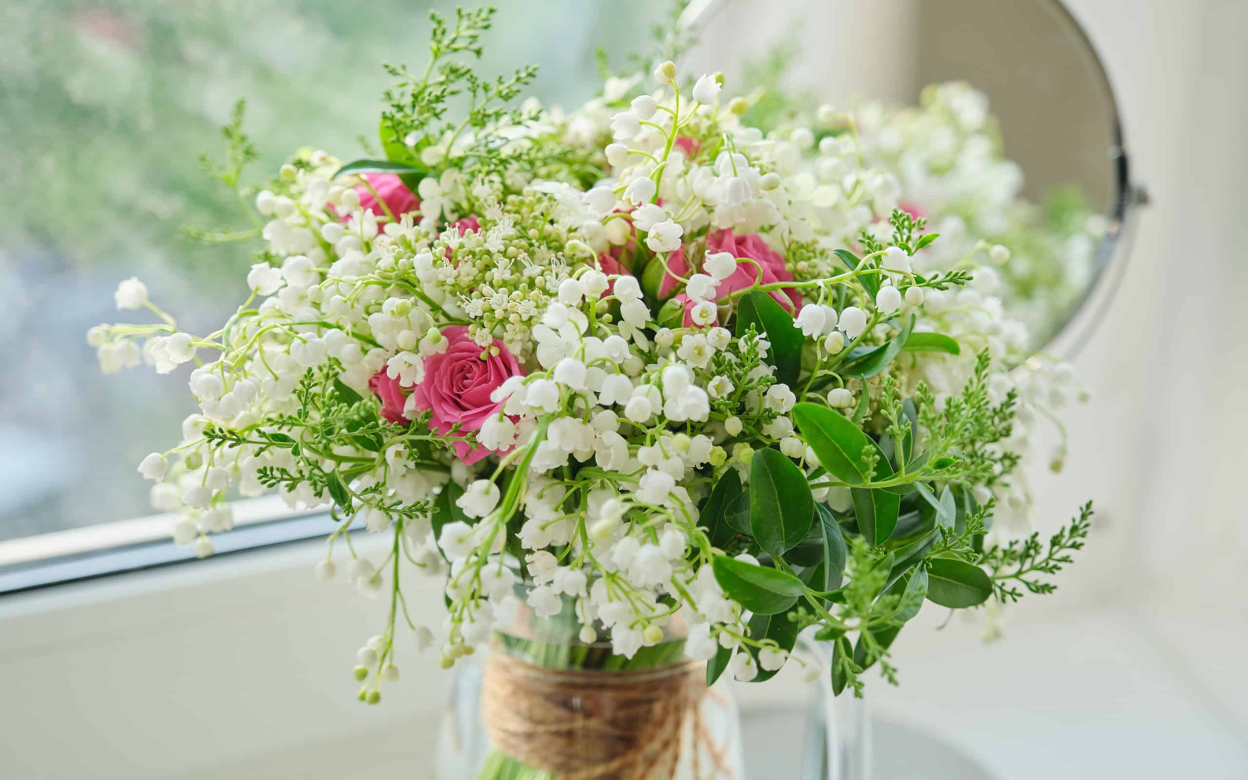 Springtime, spring fresh bouquet of lilies of the valley, pink roses, blooming viburnum
