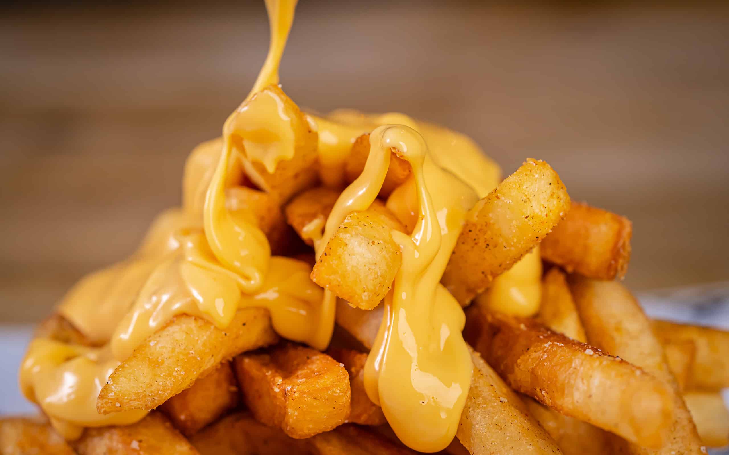Cheddar Cheese Poured or Pulled from on top Deep Fried French Fries