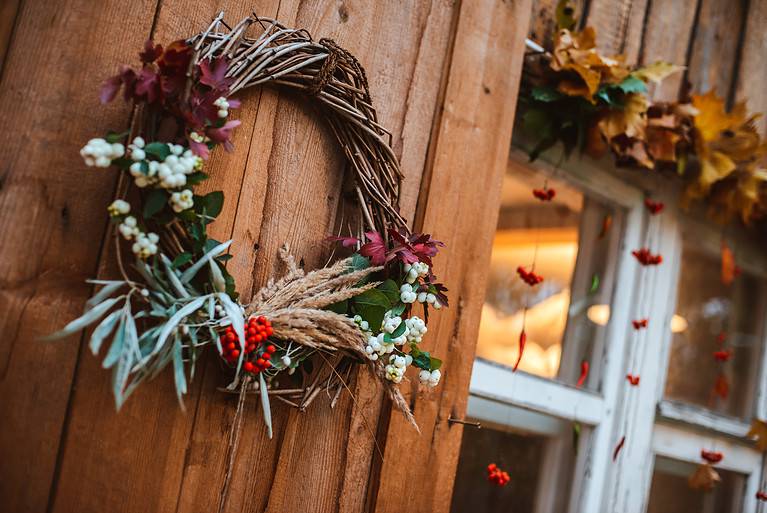 Decorative design window on the terrace. autumn wreath and pumpkins vintage old chest of drawers on wooden rustic background.