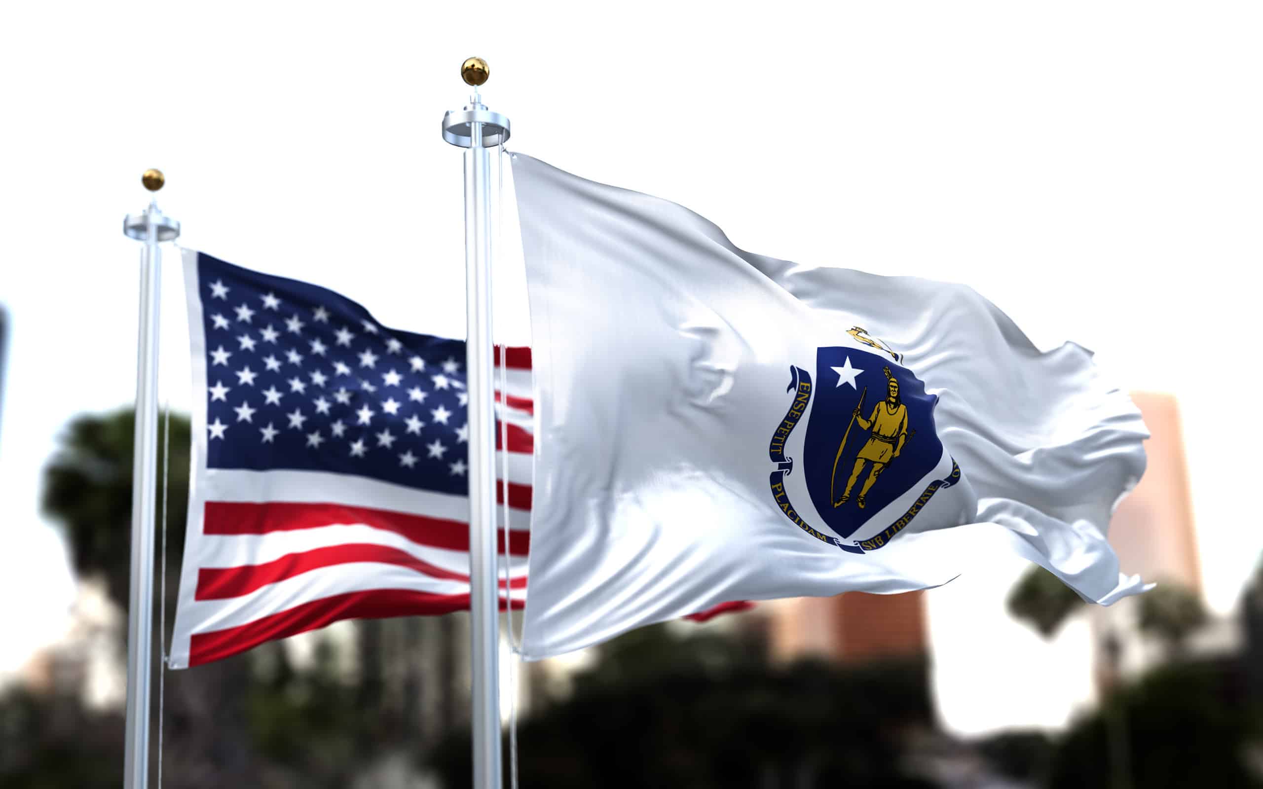 the flag of the US state of Massachusetts waving in the wind with the American flag blurred in the background