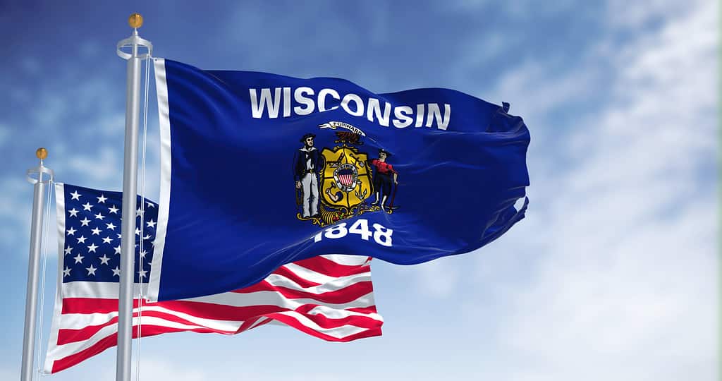 The Wisconsin state flag waving along with the national flag of the United States of America