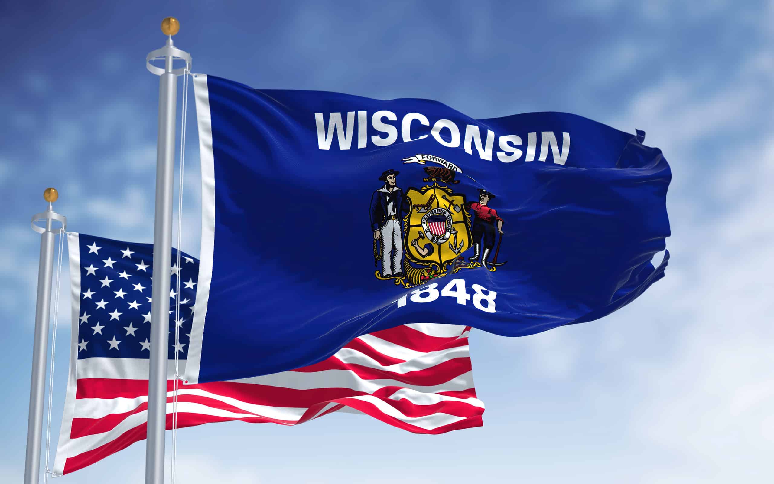 The Wisconsin state flag waving along with the national flag of the United States of America