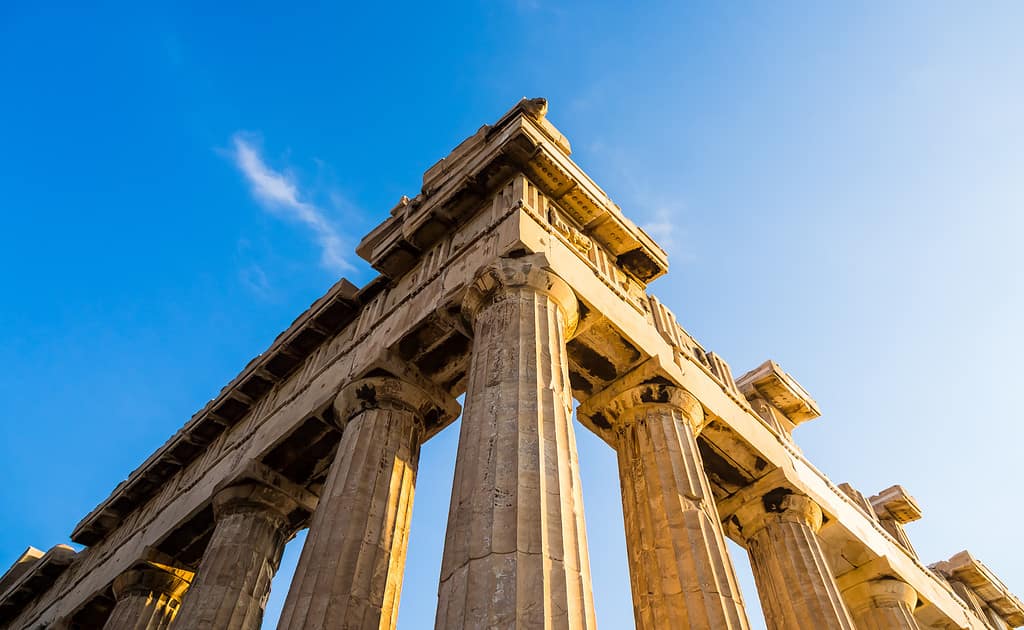 Close-up view of a corner of ancient Greek temple, remaining Doric columns and entablement at clear blue sky