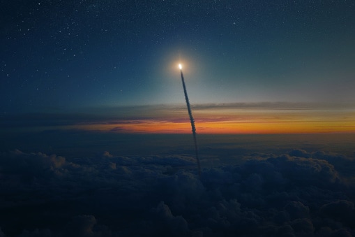 Space rocket shuttle with blast and smoke flies through clouds into starry space at sunset. Spacecraft successfully takes off from the planet Earth into outer space. Rocket launch, concept