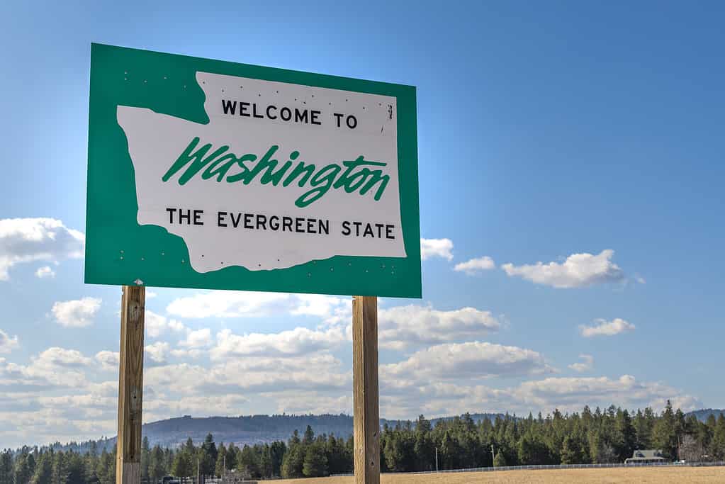 A roadside welcome to Washington the Evergreen State sign in the rural  area near Spokane, Washington, USA, coming from the state of Idaho.