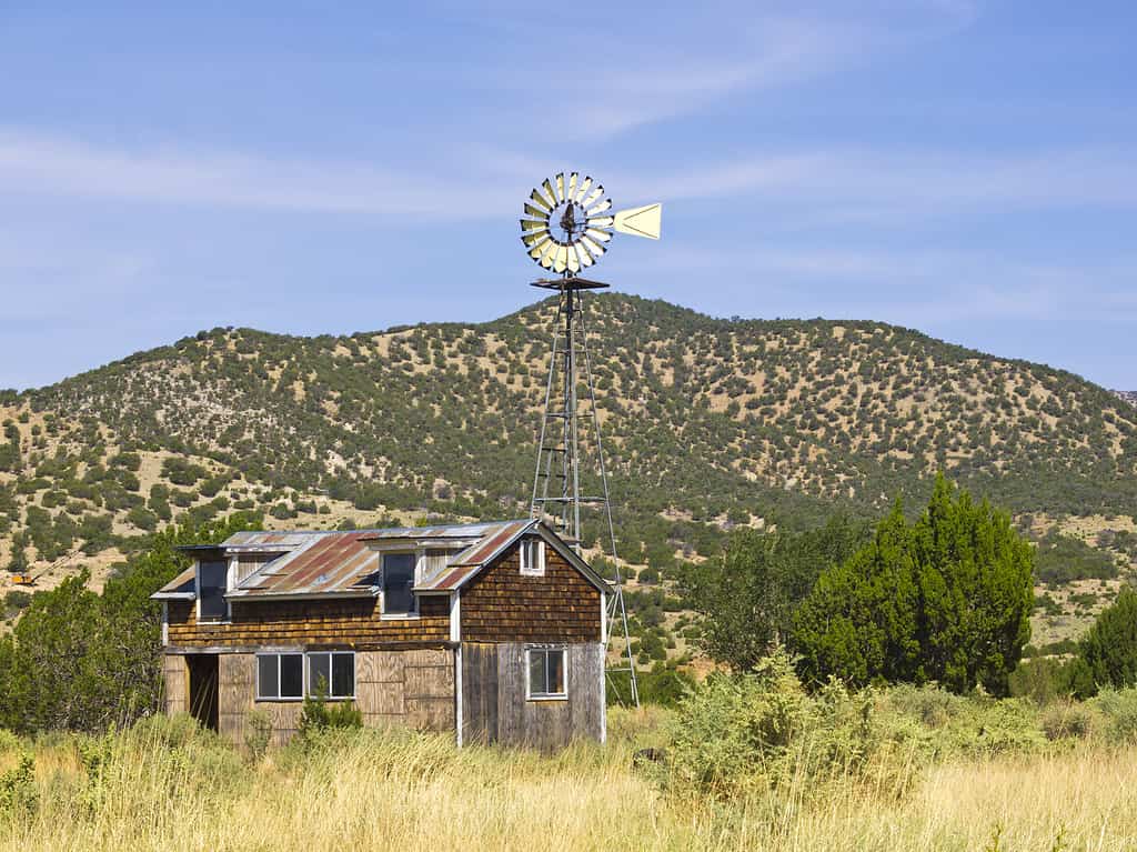 Old farm with windmill in the ghost town White Oaks, New Mexico, USA.