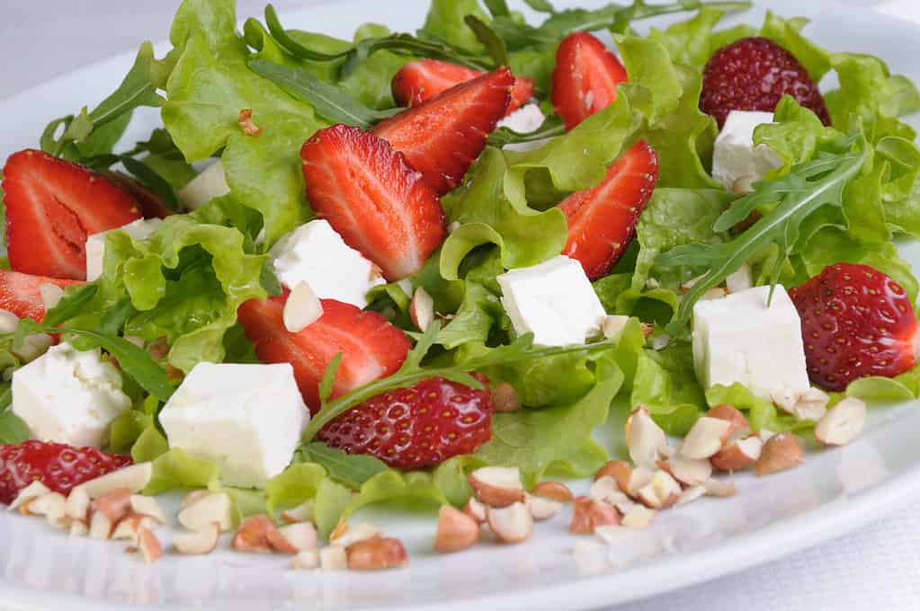 Salad of lettuce, arugula, strawberries, feta cheese and peanuts