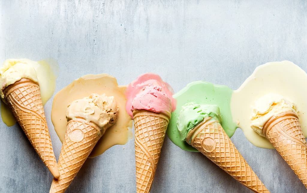Colorful ice cream cones of different flavors. Melting scoops. Top view,  steel metal backgroun