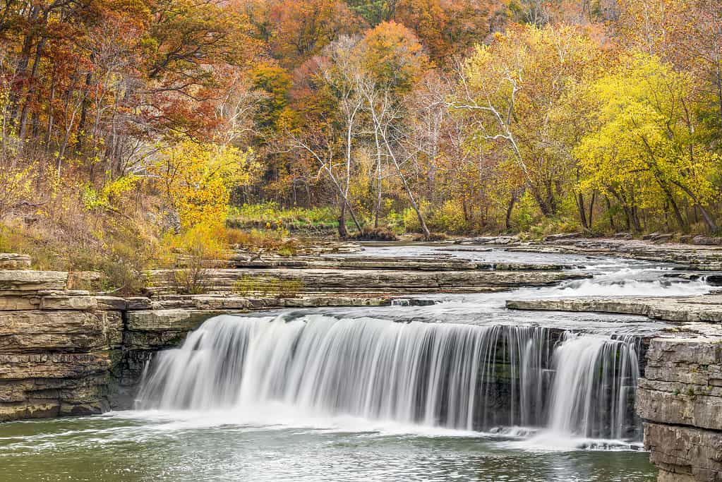 Lower Cataract Falls, a wide waterfall in Owen County, Indiana, is surrounded by beautiful fall foliage.