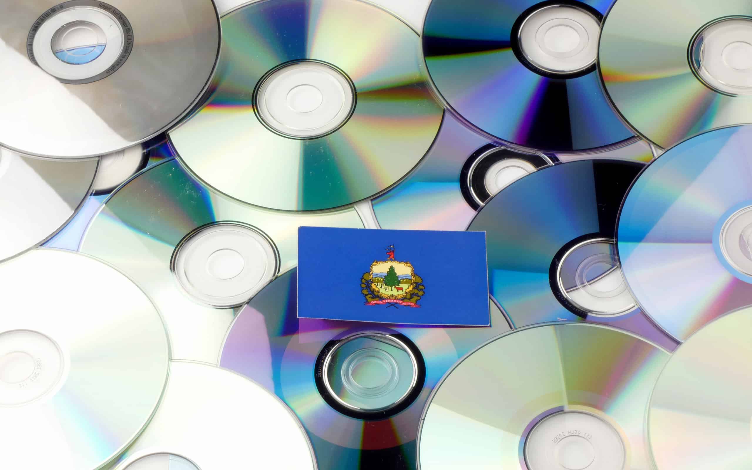Vermont flag on top of CD and DVD pile isolated on white