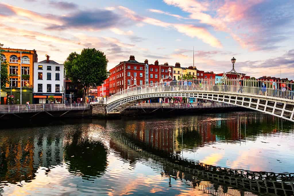 Dublin, Ireland. Night view of famous illuminated Ha Penny Bridge in Dublin, Ireland at sunset- one of 40 cities that could be underwater by 2050